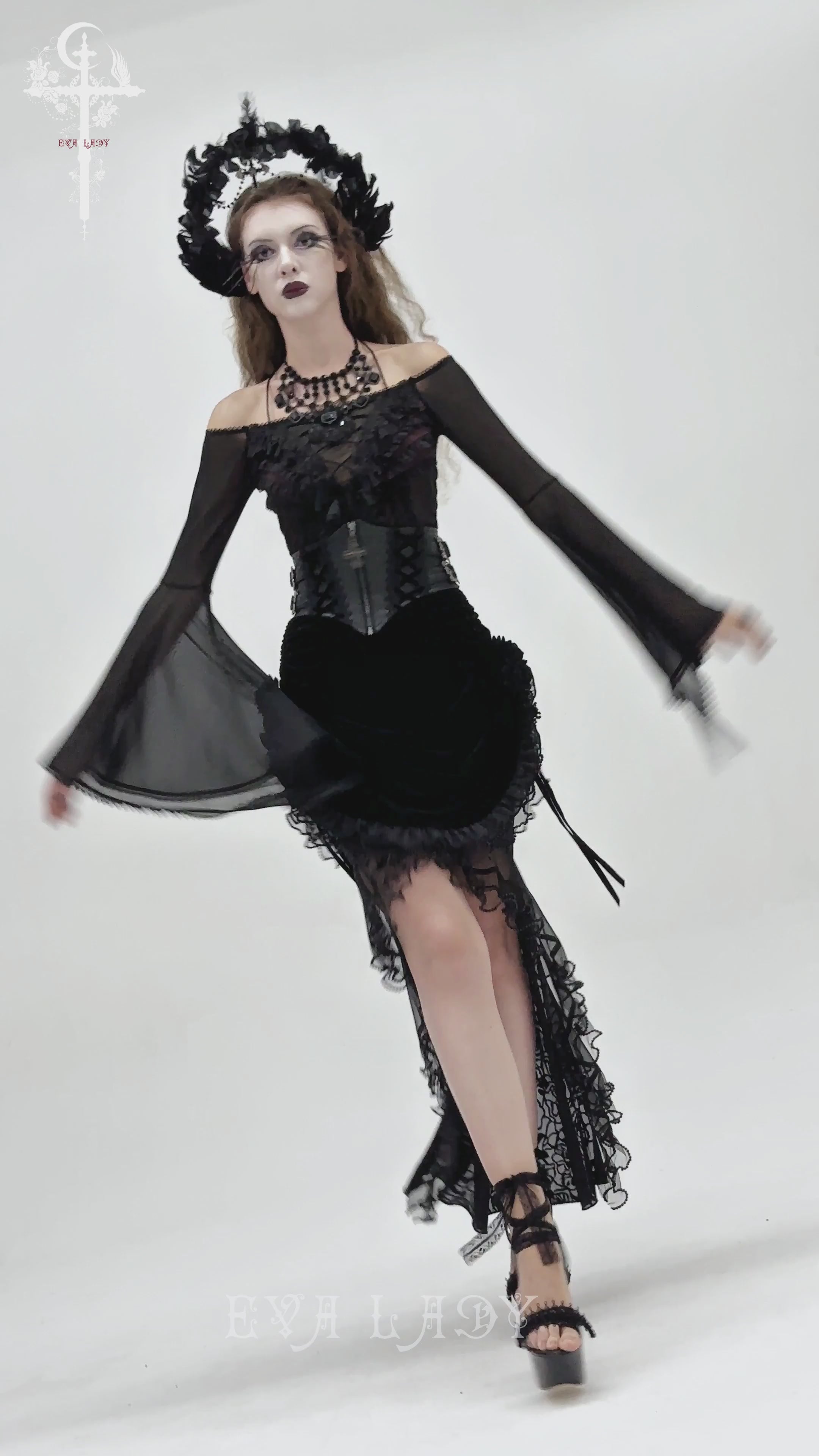 Gothic Lace-Up Black Corset Waist Belt with Cross Details worn by a model in a flowing black gothic outfit.