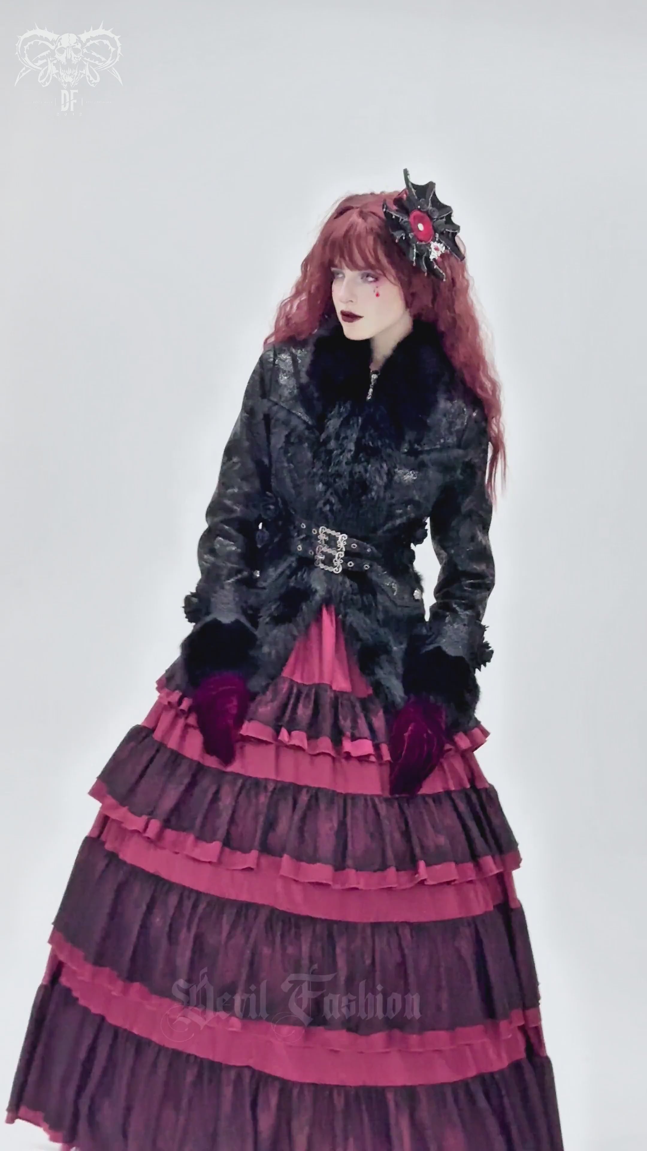 Gothic black female jacket with faux fur trim, buckle straps, and layered pink skirt for alternative fashion.