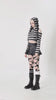 Model wearing striped bunny hooded crop top in gothic Lolita style with edgy skirt and lace-up boots.