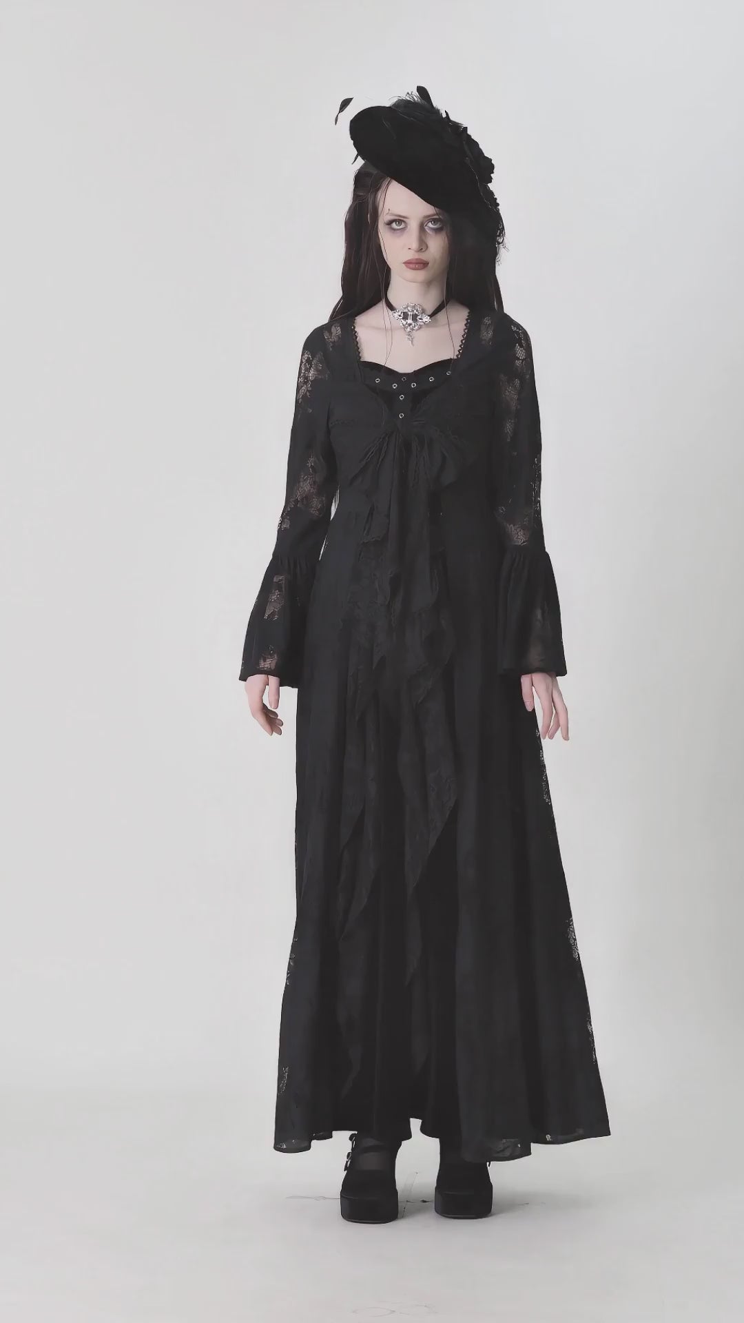 Gothic lace long-sleeved cape with floral pattern, bow tie, and dramatic bell sleeves in black.