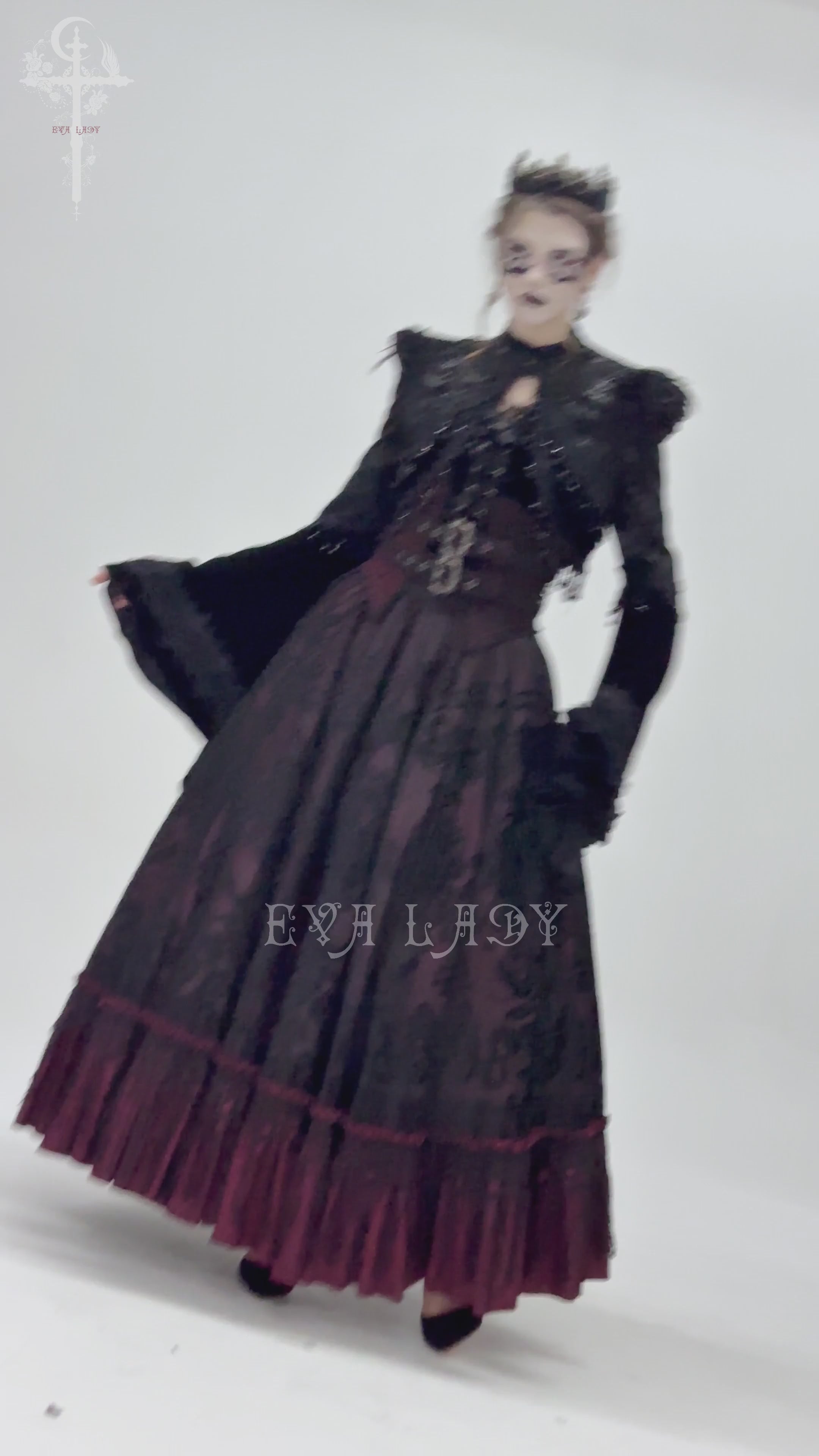 Gothic model in Victorian-inspired black dress with dramatic sleeves and lace details for a dark elegance look.