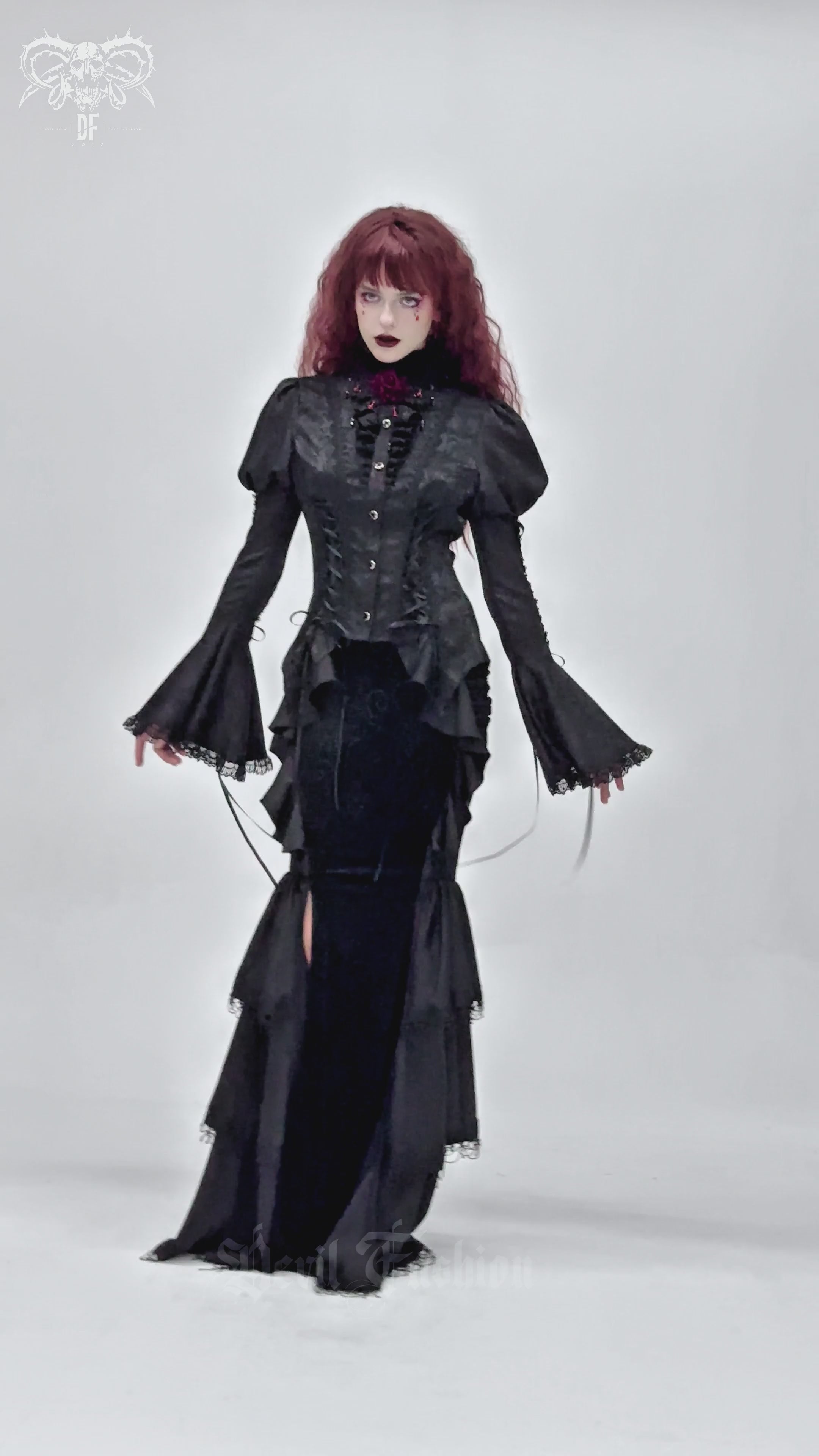 Gothic black velvet maxi skirt with ruffles, lace, and chains, worn by model in dramatic pose.