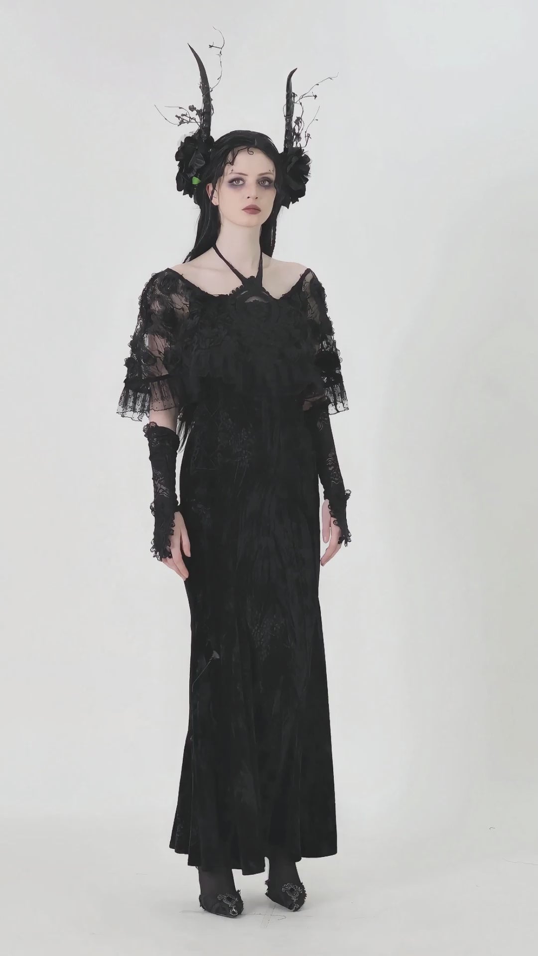 Mystical model in a Gothic lace velvet maxi dress with ruffled hem, showcasing dramatic sleeves and dark allure.