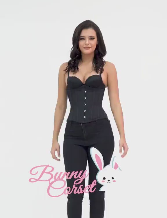 Model wearing a black waist training corset with metal busk and lacing, showcasing a defined silhouette.