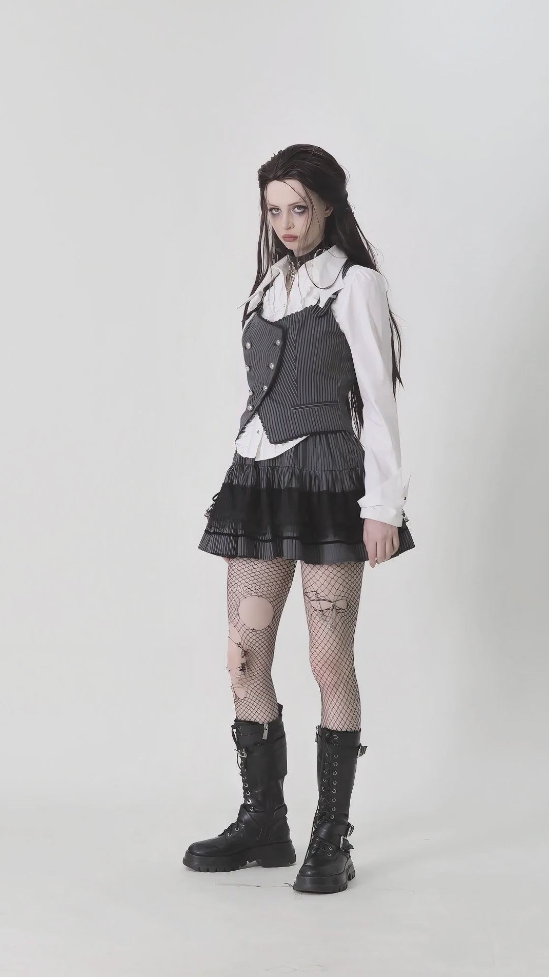 Goth pinstripe double-breasted vest styled with a white blouse, black skirt, and fishnet tights for an edgy look.
