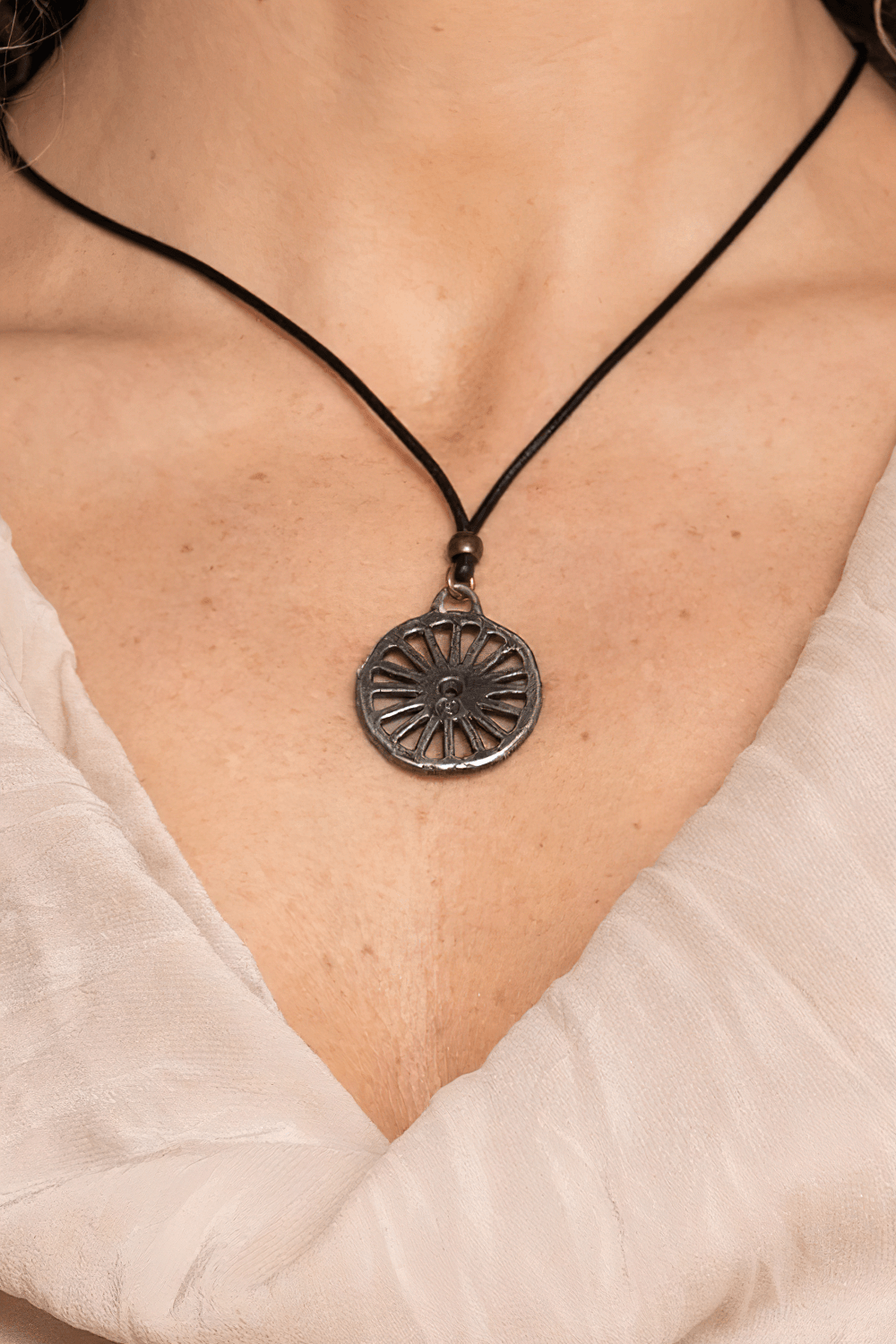 Primitive Pagan Wheel Symbol Pewter Pendant Necklace worn on black cord, showcasing rustic wheel design.
