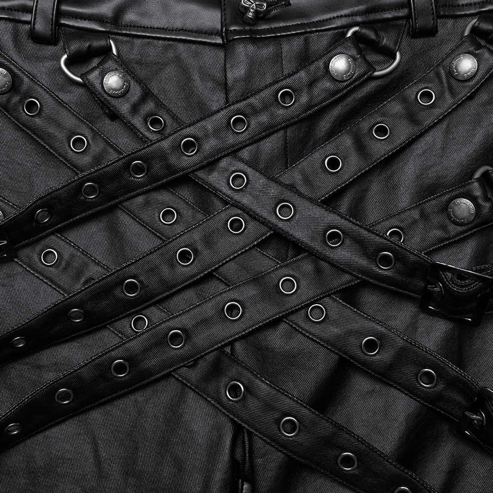 Close-up of punk-inspired black PU leather pants with bold buckle details and adjustable strap loops.