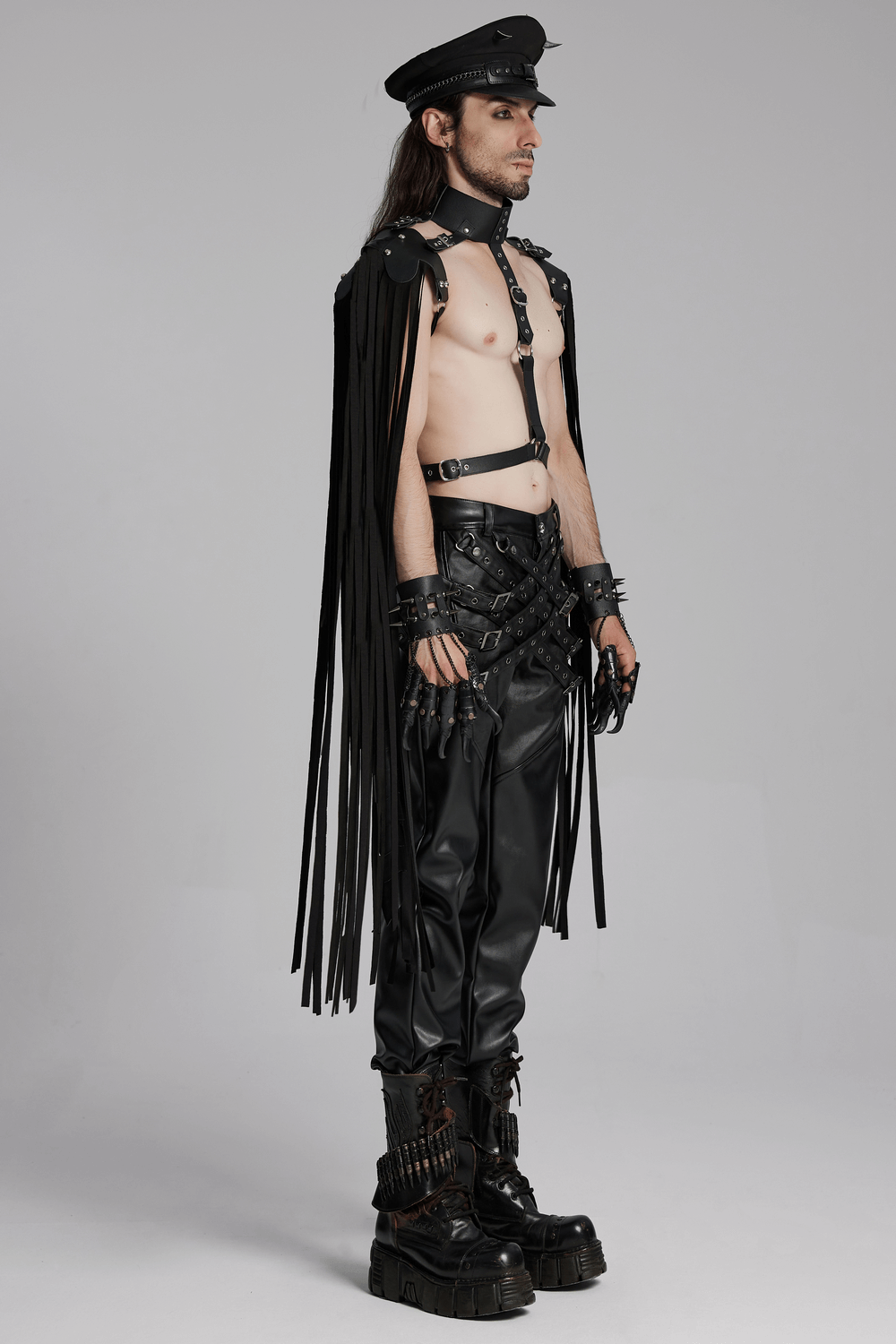 Edgy male model in punk-inspired outfit with leather pants, harness, and detailed accessories, showcasing bold streetwear style.