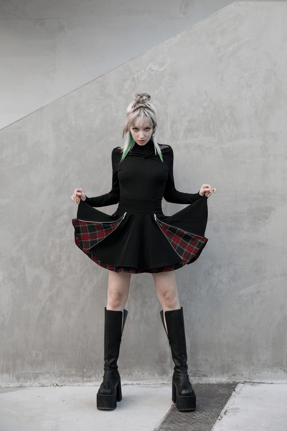 Model showcasing a punk A-line skirt with plaid detail and side zippers, paired with stylish knee-high black boots.