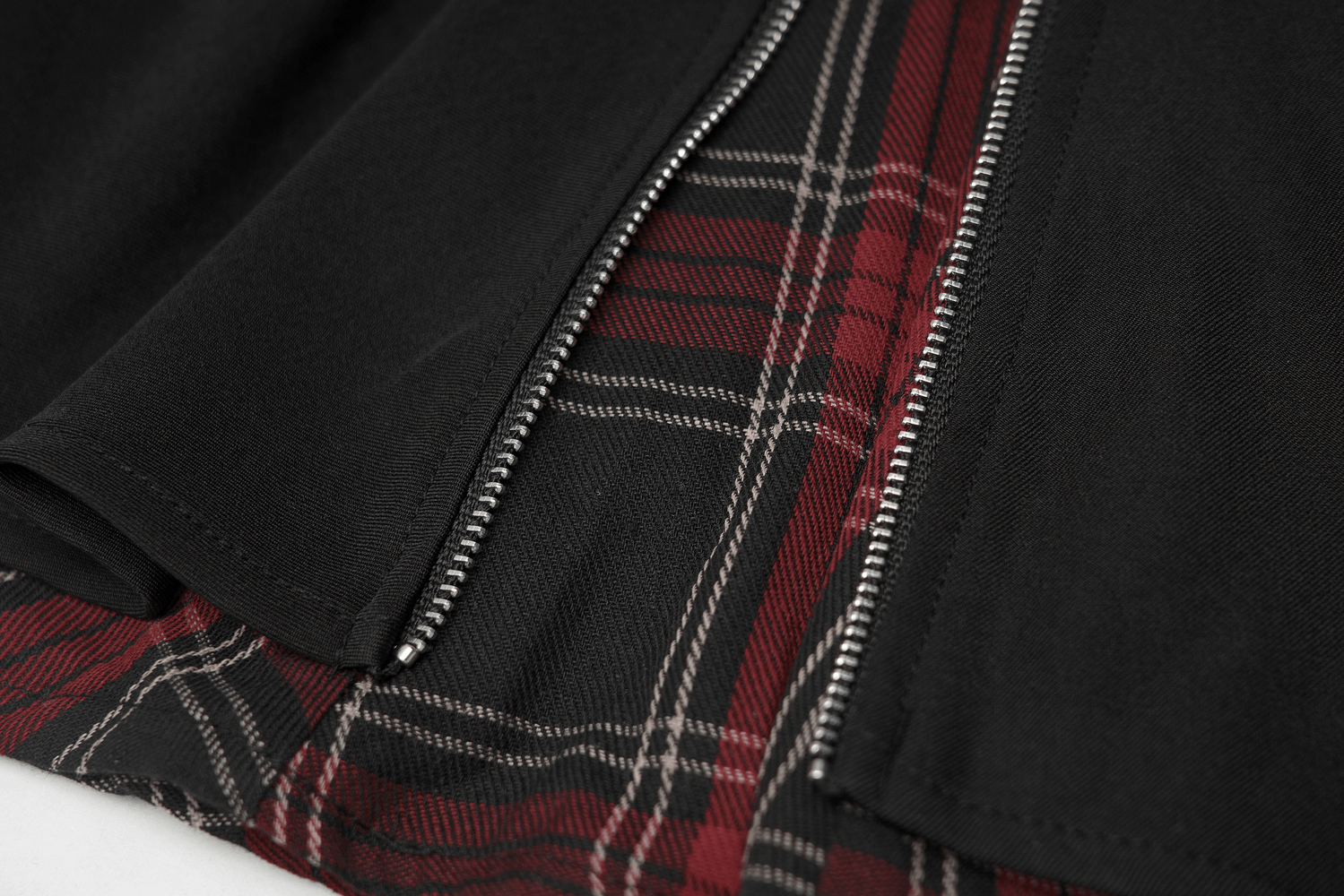 Close-up of punk A-Line skirt featuring red and black plaid detail and edgy metal zippers.