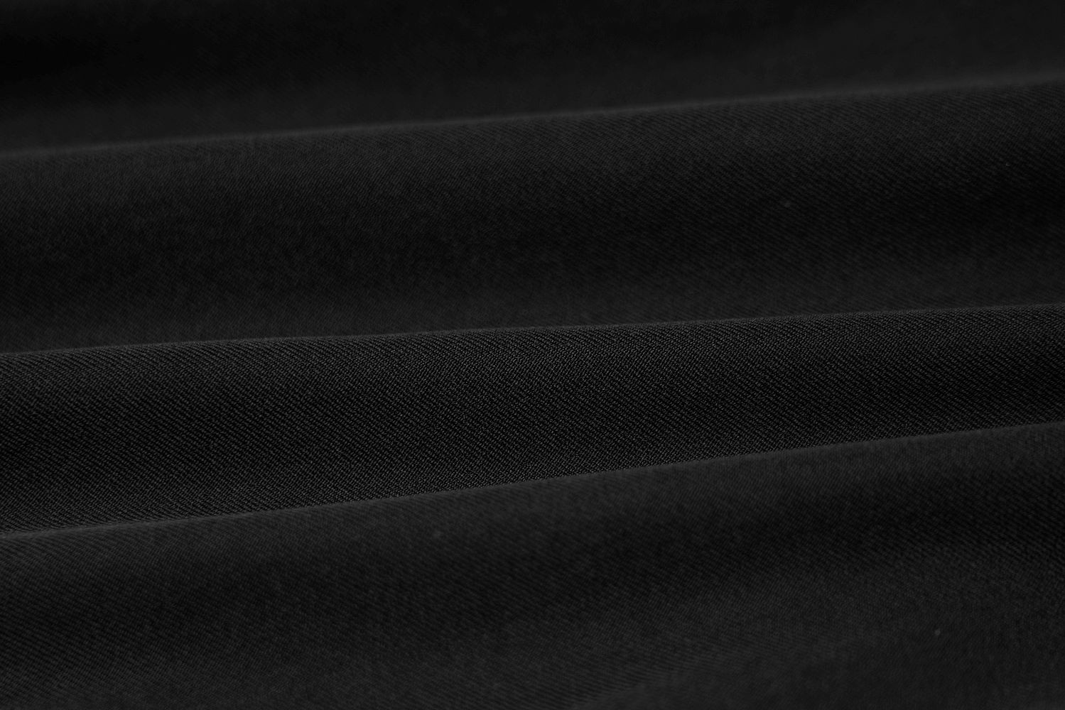 Close-up of smooth black fabric with subtle texture, ideal for stylish punk-inspired outfits.