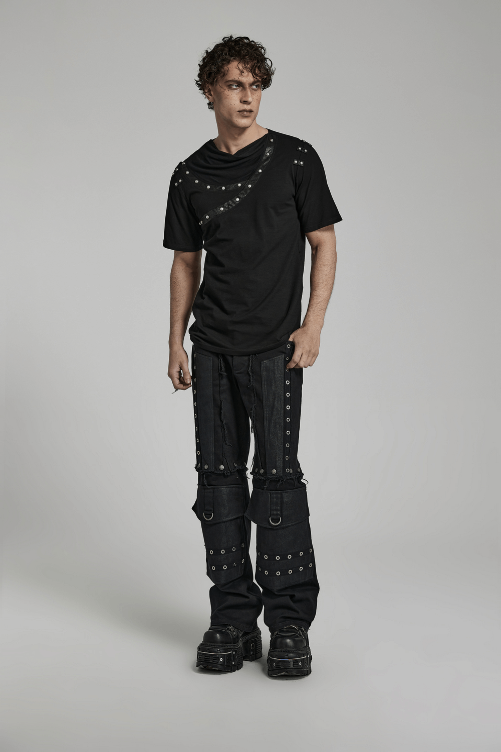 Model wearing a Punk asymmetric cracked leather T-shirt with rivets and grunge-style pants, exuding edgy fashion.