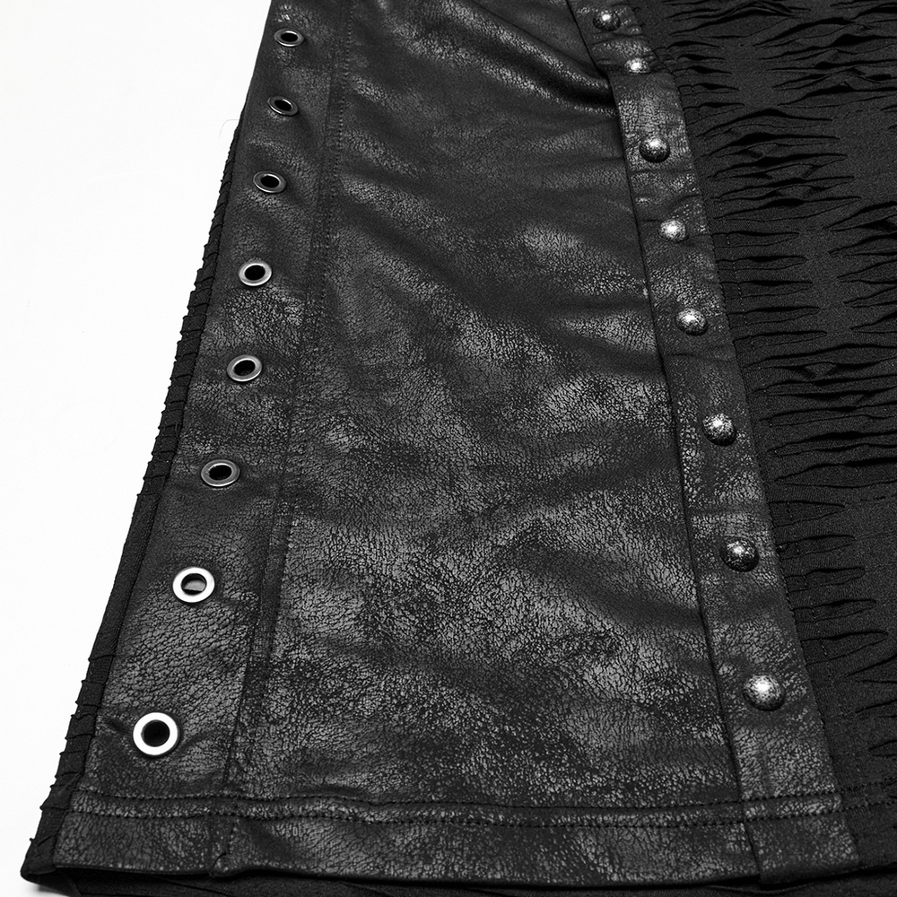 Close-up of punk-inspired black fabric with rivets and tattered texture, showcasing edgy fashion detail.
