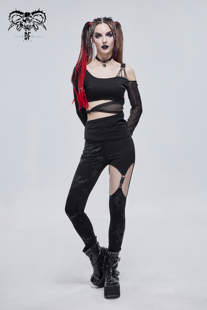 Women in punk fashion flaunts asymmetrical black leggings and edgy top, showcasing a bold style statement.