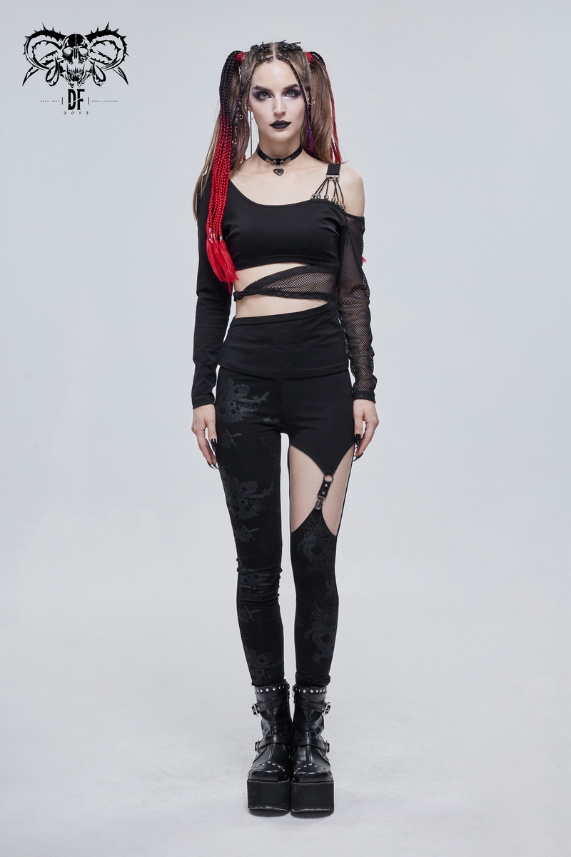 Punk style woman in asymmetrical black leggings with cutouts and a crop top, showcasing edgy fashion and unique style.