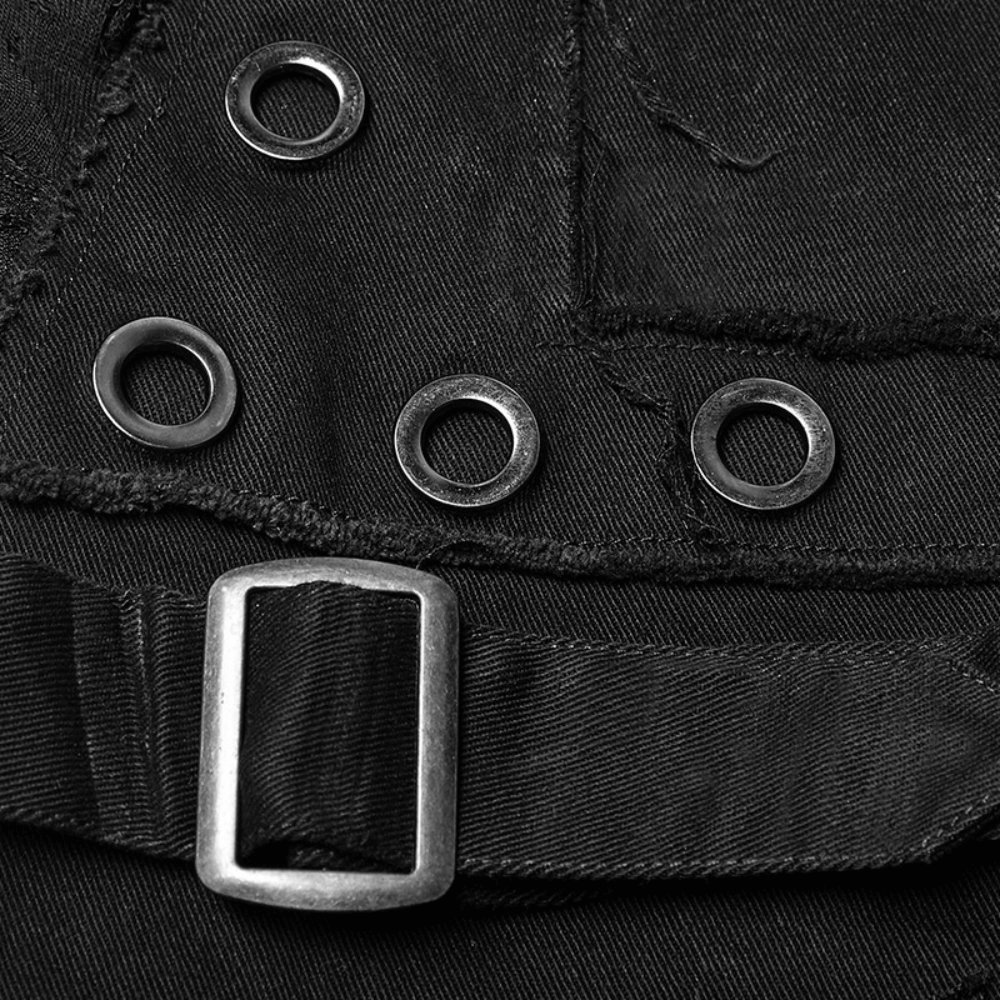 Close-up of punk black destroyed jeans showing lace, buckle, and rivet details for edgy vintage style.