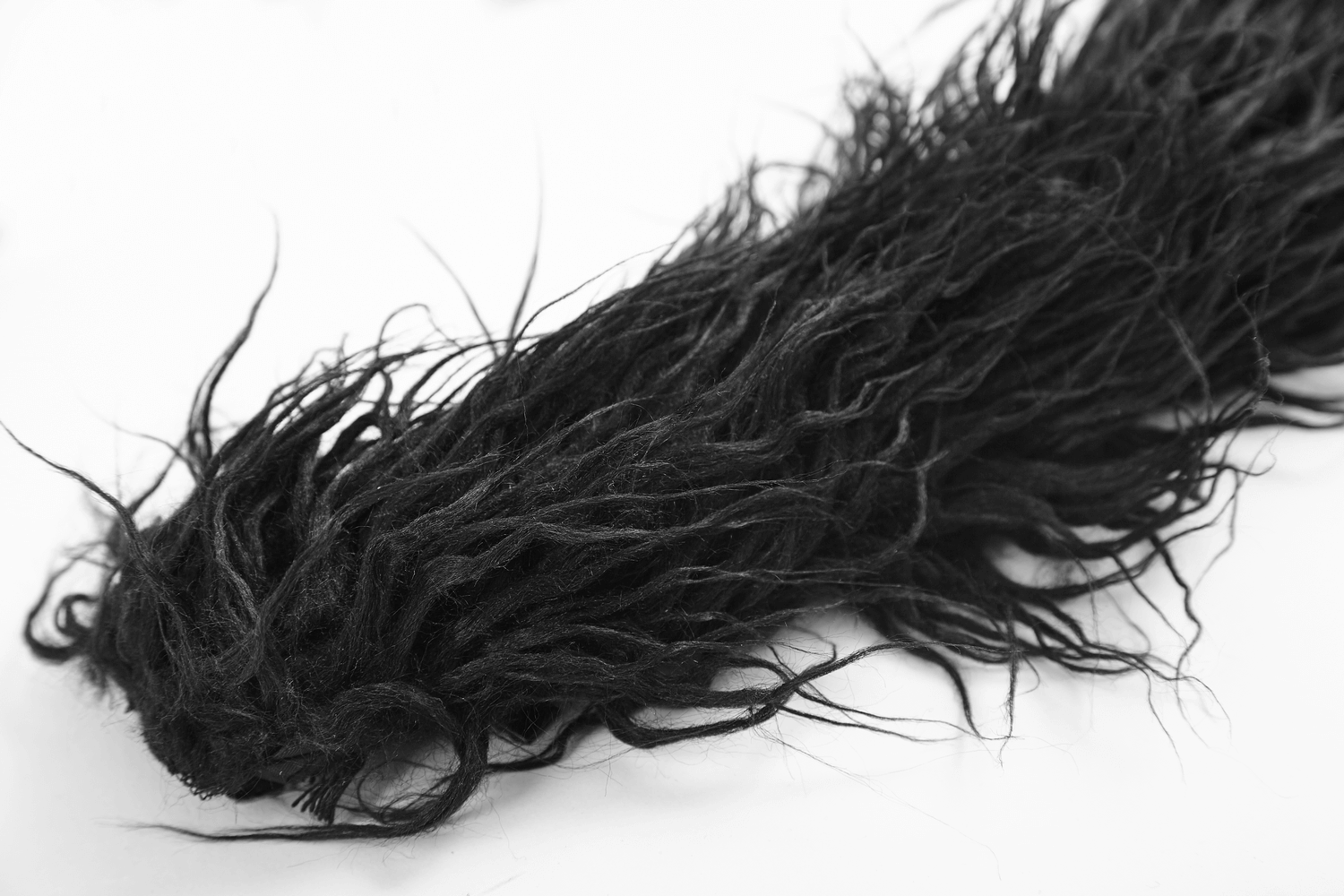 Textured black faux fur resembling mohawk hair detail on a white background.