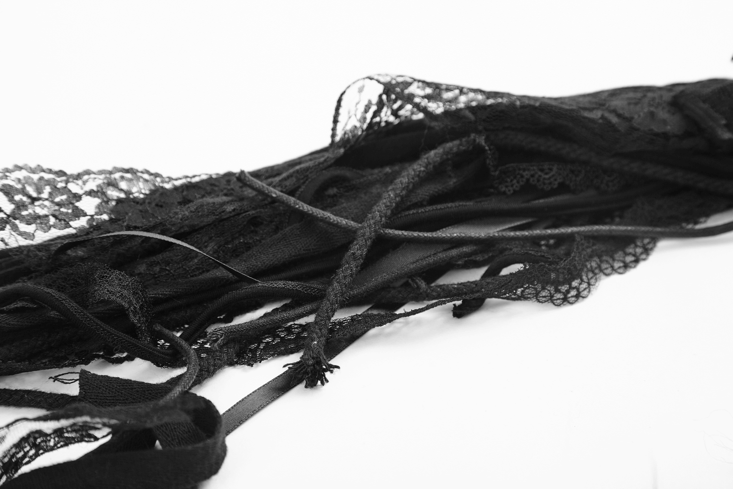 Close-up of assorted black lace and ribbon pieces, perfect for punk and gothic fashion accessories.