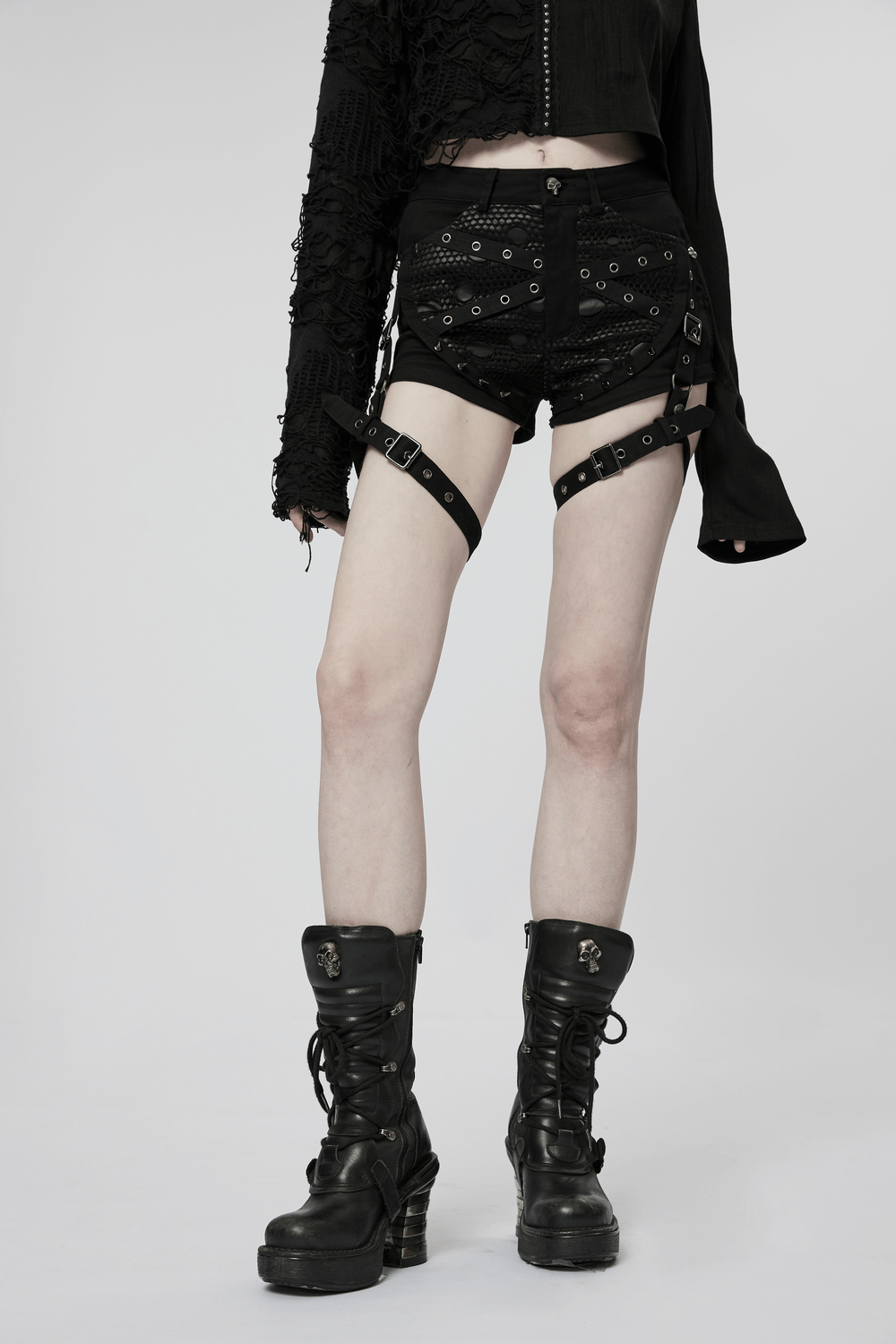 Punk black mesh garter shorts with buckle straps, featuring edgy design, paired with stylish black combat boots.