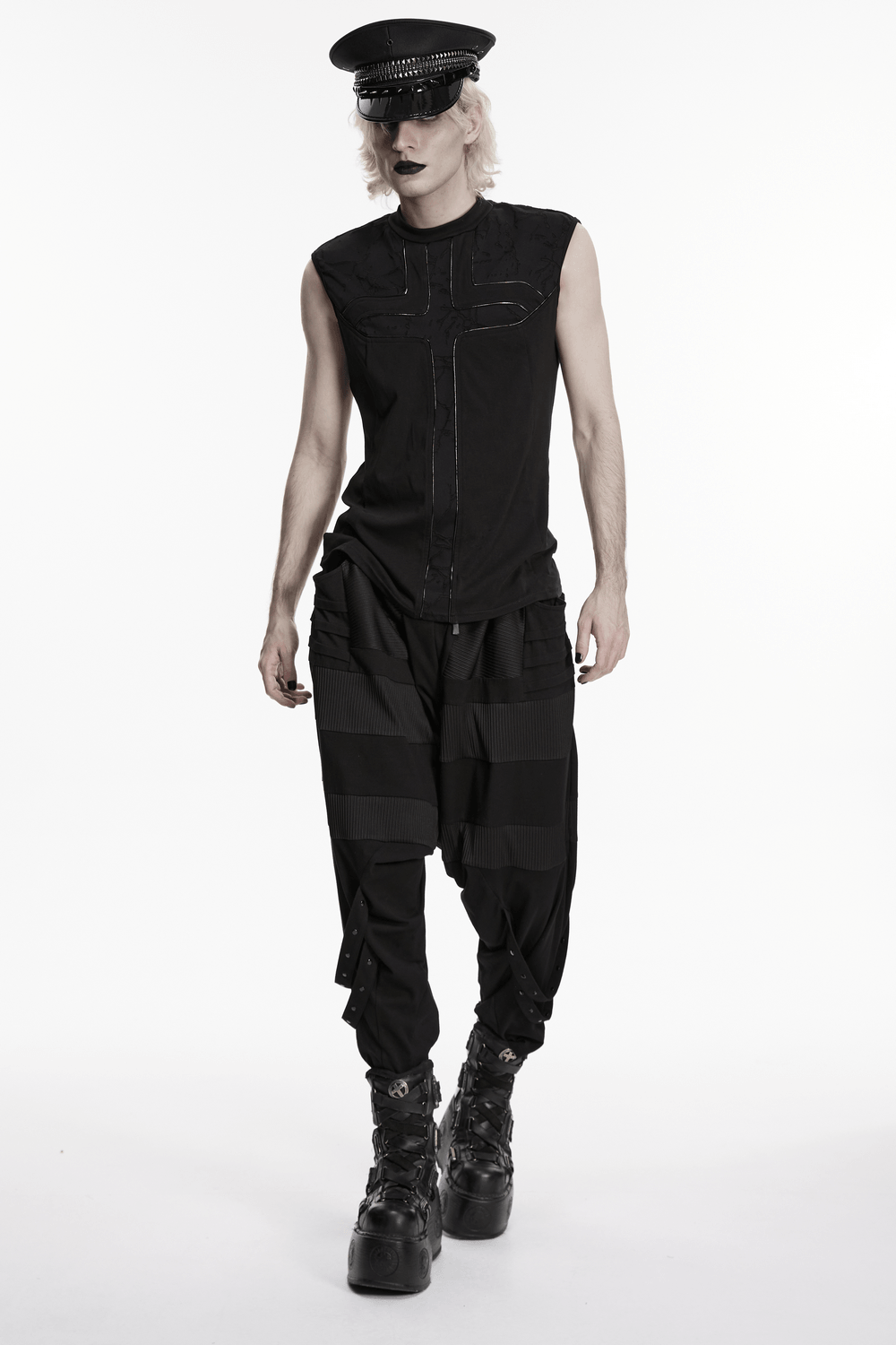 Punk Black Minimalist Cross Sleeveless Gothic Top worn with black trousers and a stylish hat, showcasing a bold alternative fashion style.