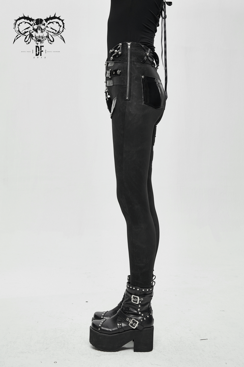 Punk black pants with pentagram harness belts and vinyl pockets, styled on a model in edgy footwear.