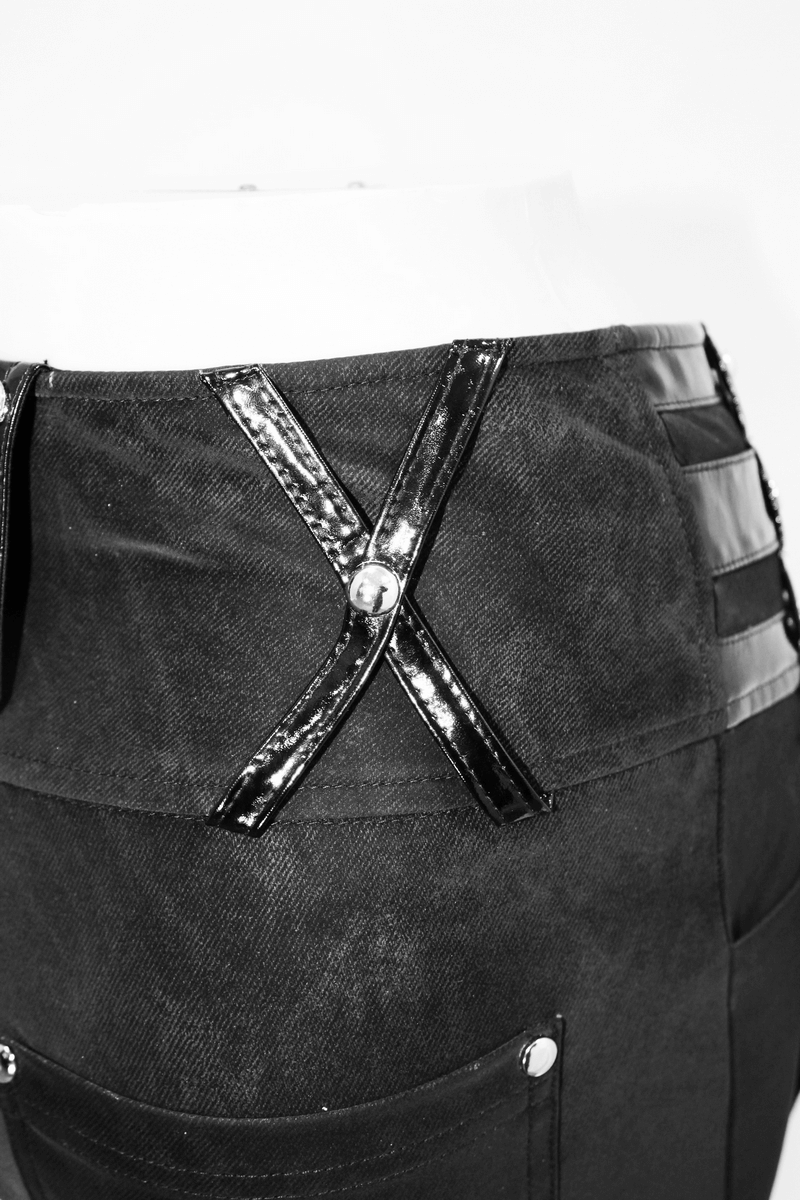 Close-up of punk women's black pants with pentagram harness belts and patent leather details.