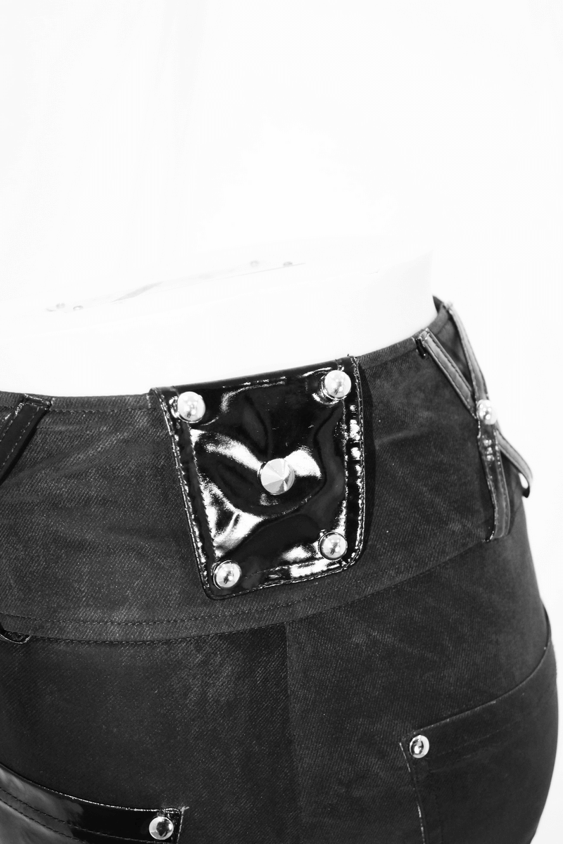 Close-up of punk black pants featuring pentagram harness belts and vinyl pocket details.