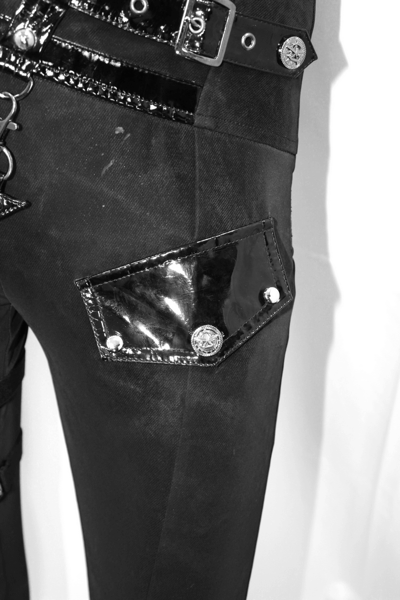 Close-up of punk black pants showcasing shiny patent pockets and silver rivets for a bold style.