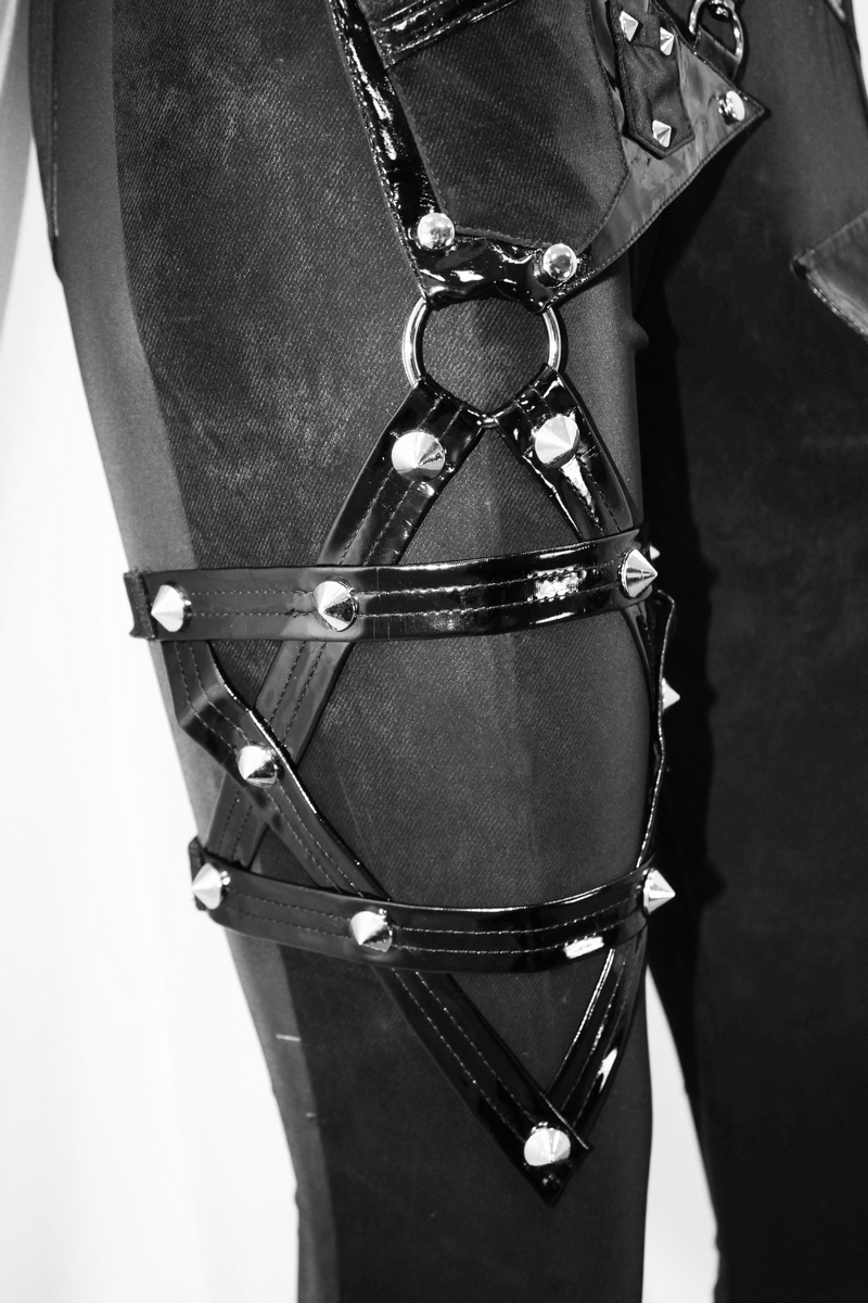 Close-up of women's punk black pants featuring pentagram harness belts and rivets for a bold style.