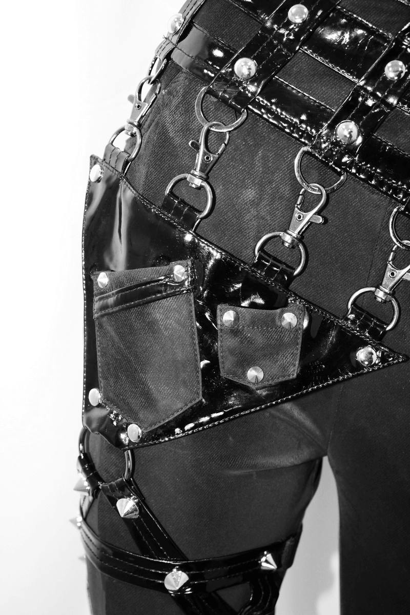 Close-up of women's punk black pants with pentagram harness belts and vinyl pockets, adorned with silver metal rivets.