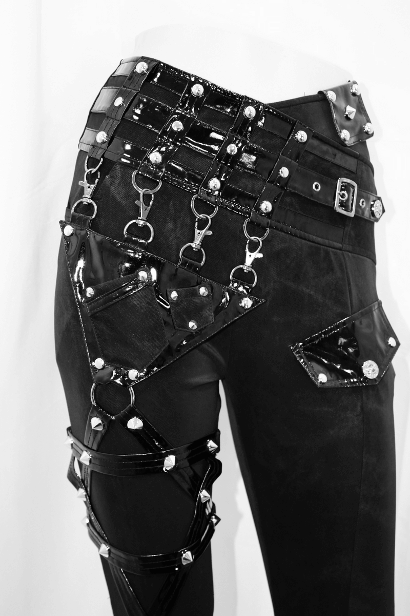 Close-up of women's punk black pants featuring pentagram harness belts and shiny vinyl pockets.