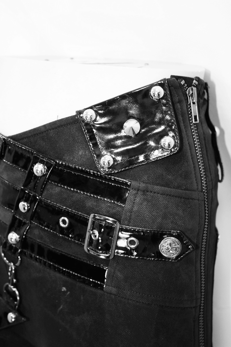 Close-up of punk black pants featuring pentagram harness belts and zipper with shiny vinyl pockets for women.
