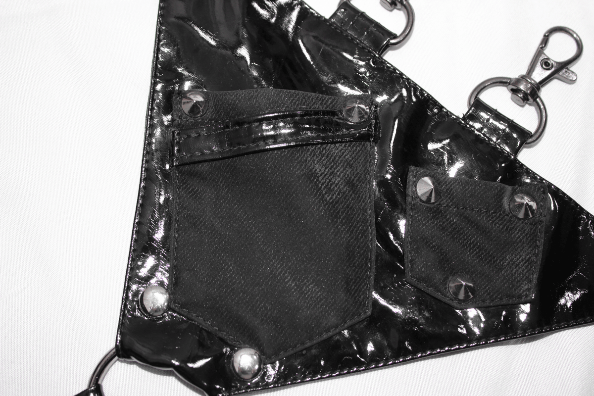 Close-up of black pentagram harness with shiny vinyl pockets and rivets, perfect for punk fashion.