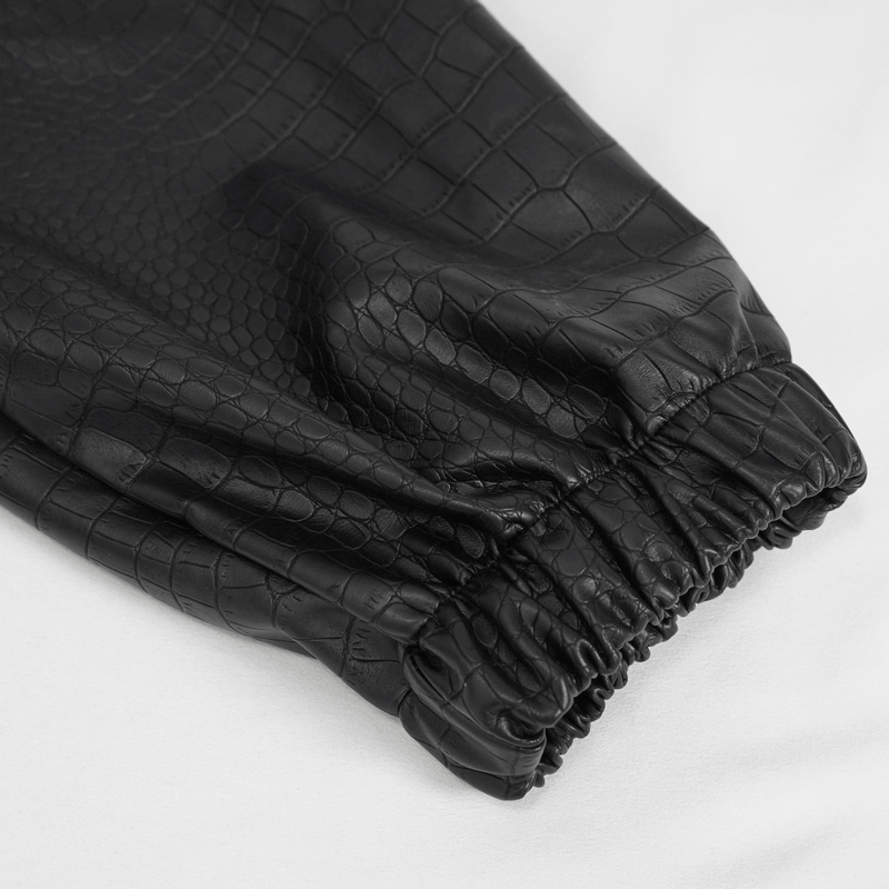 Close-up of black PU leather cargo pants with a stylish croc texture and elastic cuff, perfect for punk fashion enthusiasts.