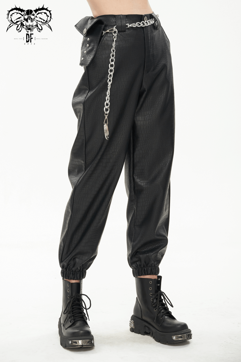 Punk black PU leather cargo pants for women with metal chain and small waistbag, paired with stylish boots.