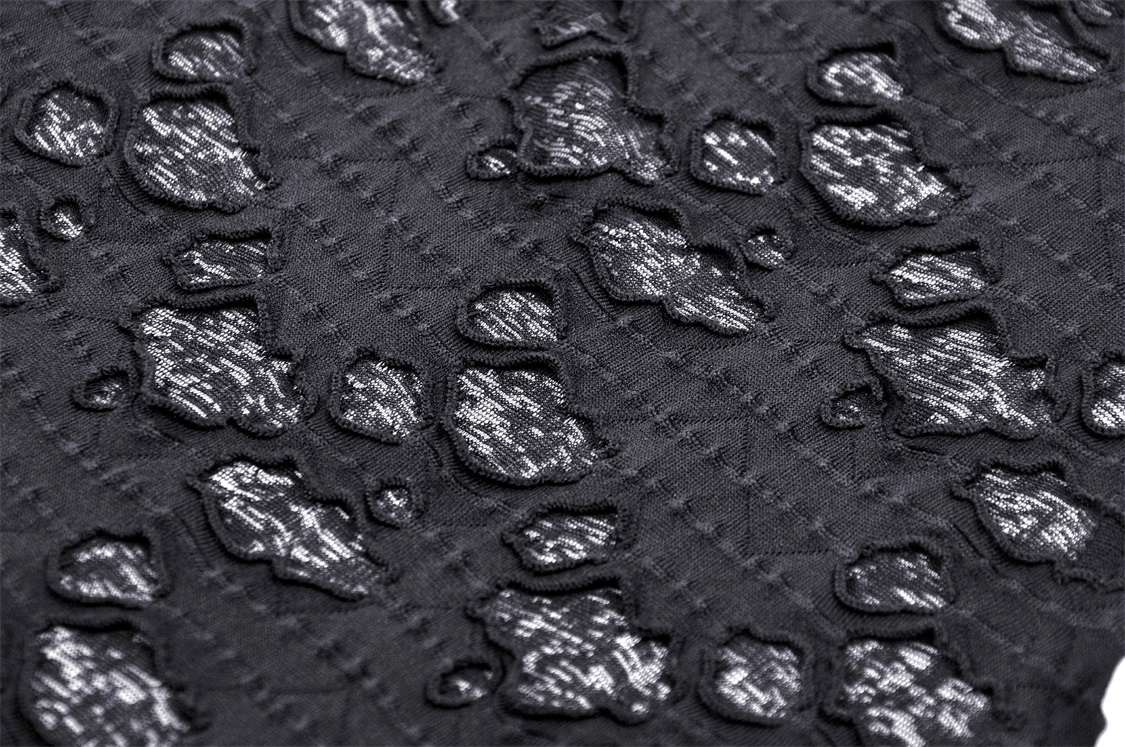 Close-up of textured black fabric featuring a unique embossed pattern for edgy fashion designs.