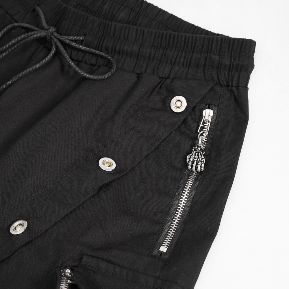 Close-up of black punk cargo pants featuring metal buttons and zippers for a trendy look.