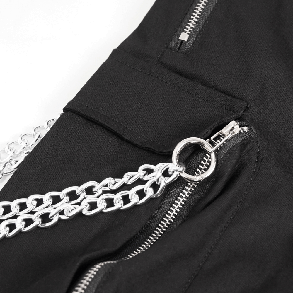 Close-up of punk cargo pants featuring metal zippers and detachable silver chain for a trendy gothic look.