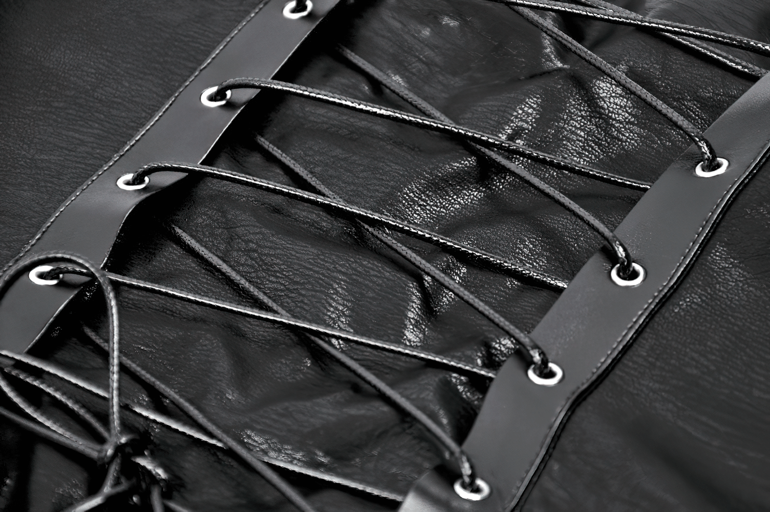 Close-up of a punk corset top featuring spiked details and a sleek zipper closure, showcasing intricate lacing.