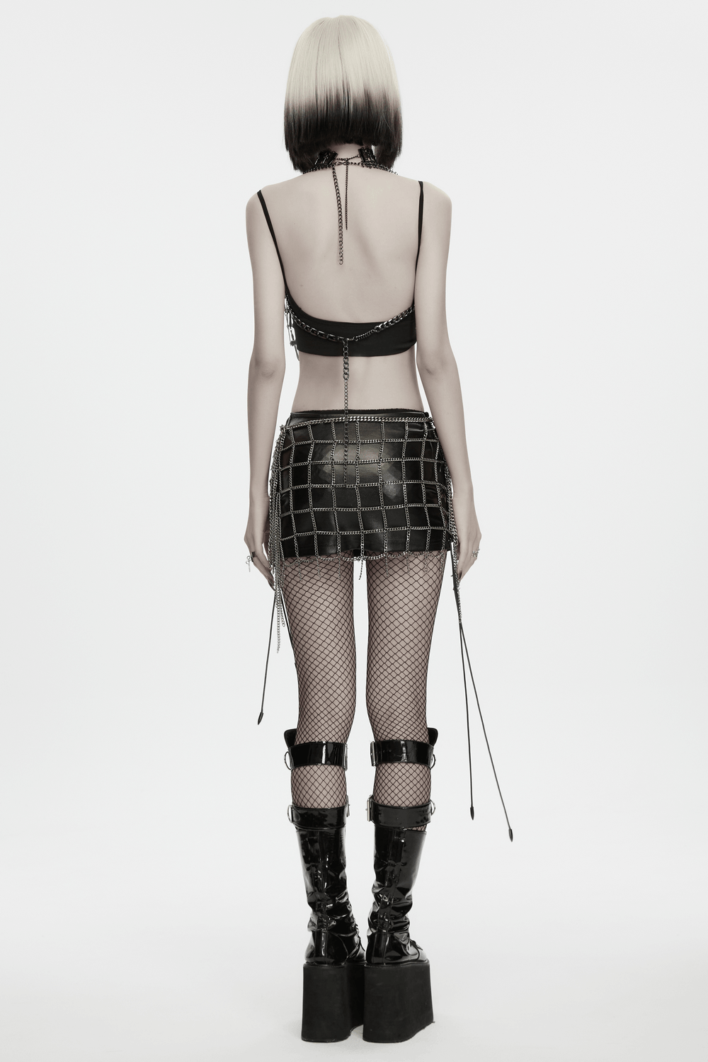 Punk Cross Cage Skirt with Vintage Metal Chain Details worn with a black top and tall shiny boots, showing bold gothic style.