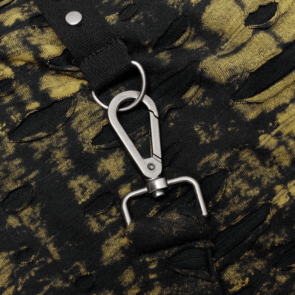 Close-up of distressed black and yellow knit fabric with a metal clip detailing on the Punk Cross Mini Skirt.