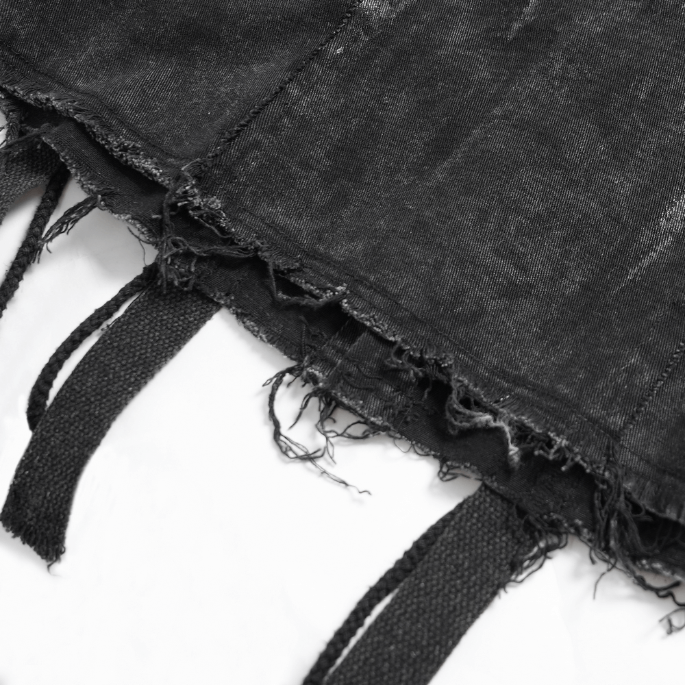 Close-up of punk denim shirt showcasing lace-up sides and distressed black fabric detail.