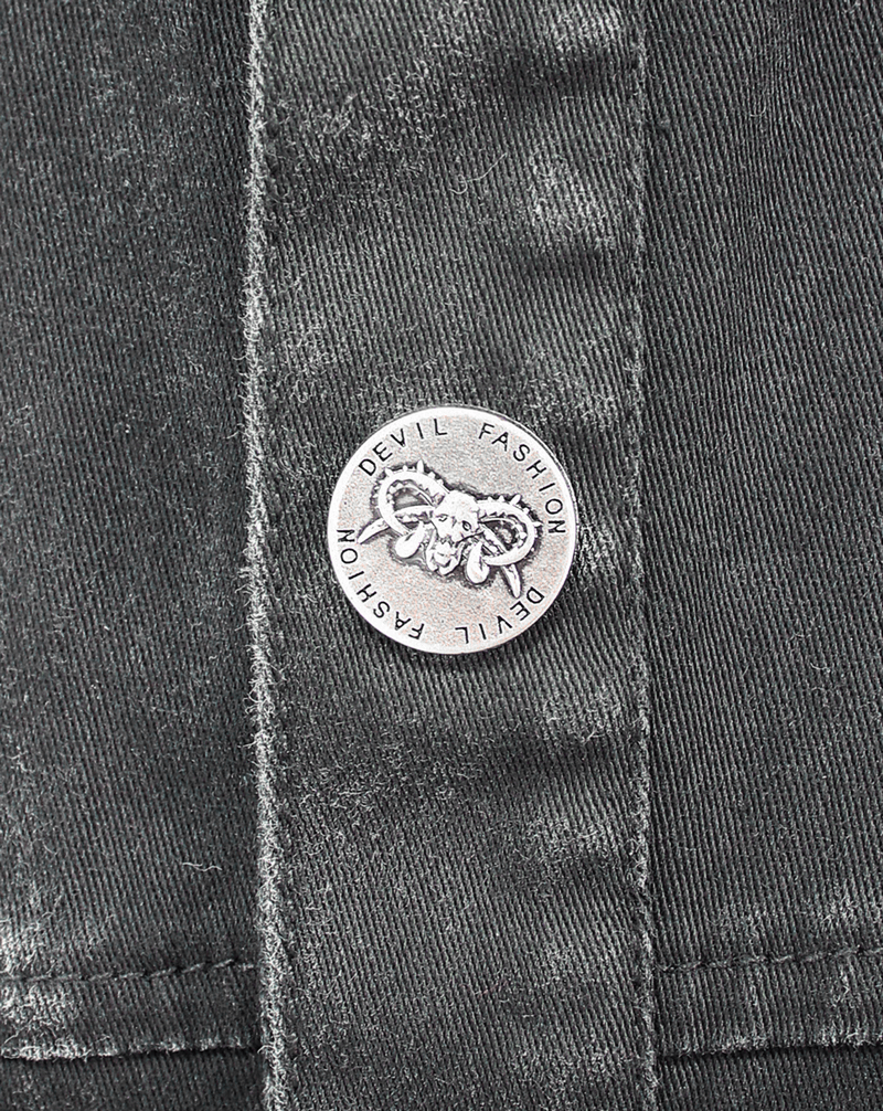 Close-up of silver button detail on a black denim punk vest, featuring the 'Devil Fashion' logo.