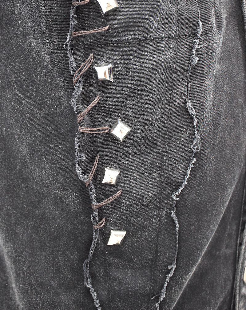 Close-up of black denim vest detailing with silver studs and frayed edges, showcasing punk style features.
