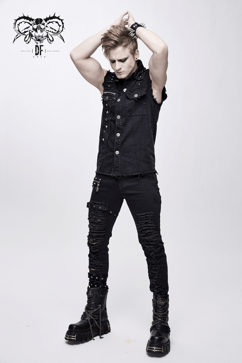 Man in punk black denim sleeveless vest and ripped jeans, showcasing edgy alternative fashion with chunky boots.