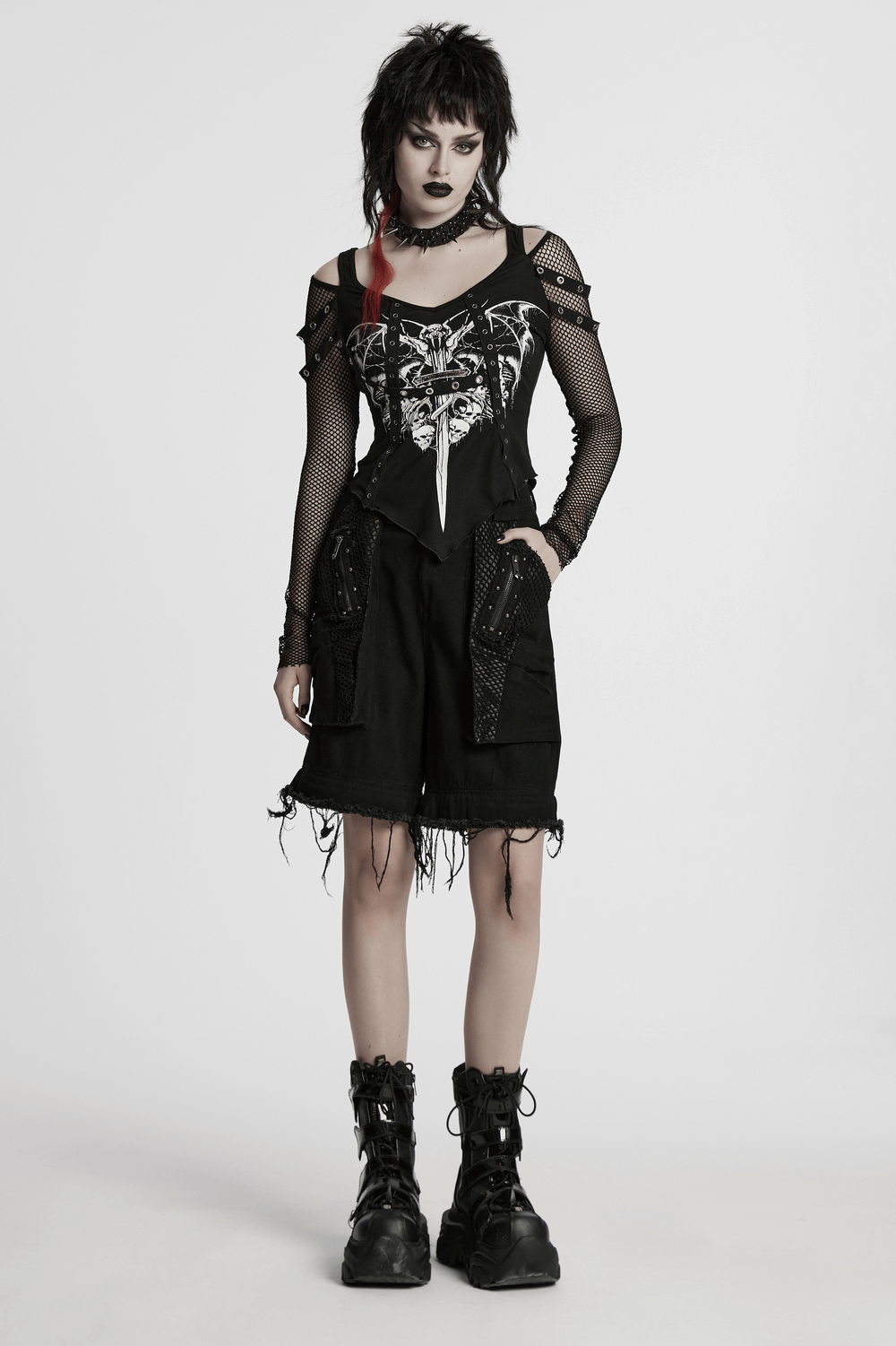 Punk fashion model in black detachable mesh and studded wide-leg pants with edgy graphic top and bold accessories.