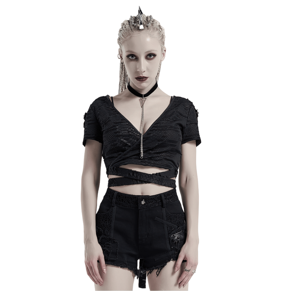 Edgy punk cropped V-neck t-shirt with ripped details and unique 3D fabric, styled with black shorts.