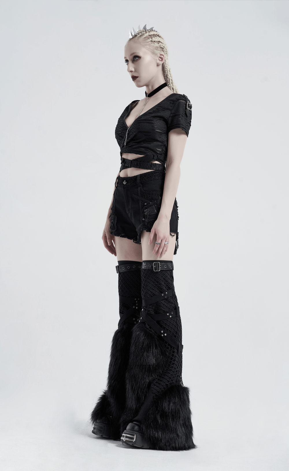 Edgy punk model wearing black distressed outfit with cropped top and furry boots, perfect for Gothic fashion lovers.