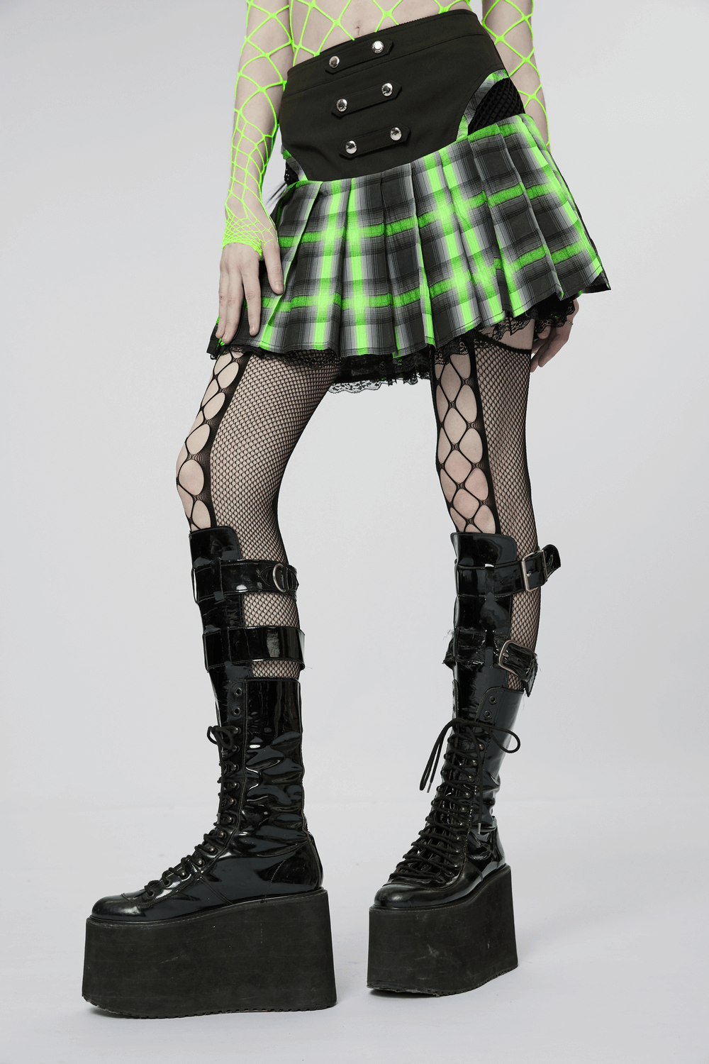 Punk female plaid skirt with lace, snap buttons, and fishnet tights, showcasing a bold, edgy style.