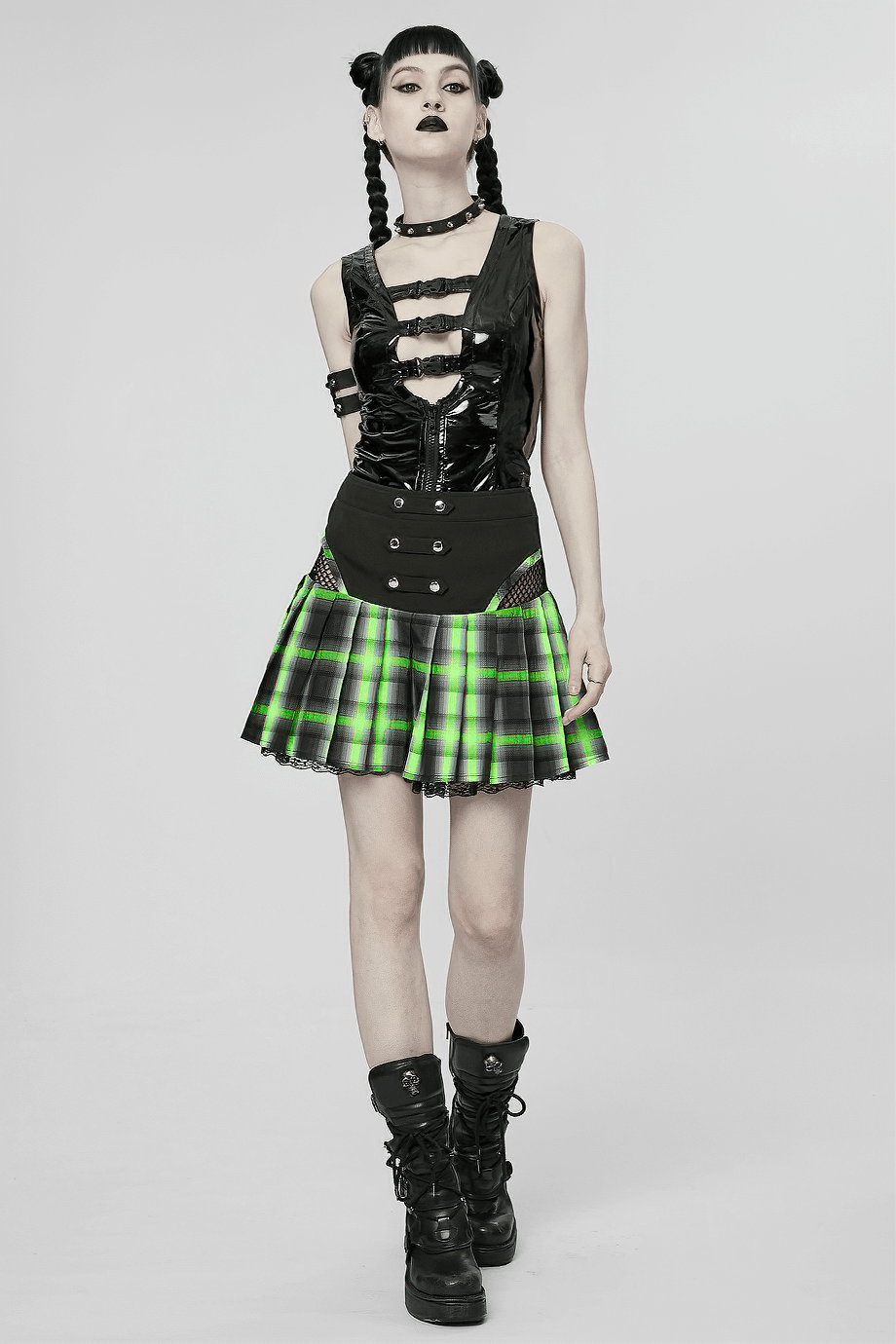 Punk female model in a plaid skirt with lace, snap buttons, and hollow sides, showcasing edgy fashion.